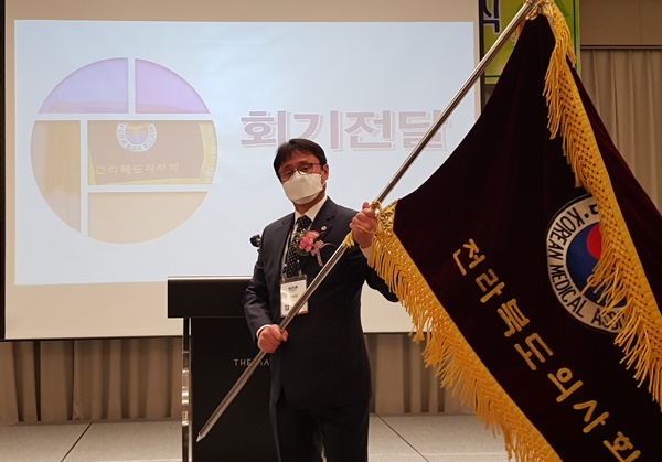 ▲ 김종구 신임회장이 전라북도의사회 회기를 흔들어 보이고 있다.