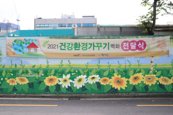 ▲ 한국건강관리협회는 지난 13일(월) 서울시 동대문구 용신동주민센터 앞에서 건강마을가꾸기 벽화 전달식을 개최했다.