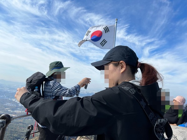 ▲ 백운대에는 태극기가 바람에 펄럭인다. 인증샷을 날리기 위해 뒤에 제법 많은 줄들이 이어지고 있었다.