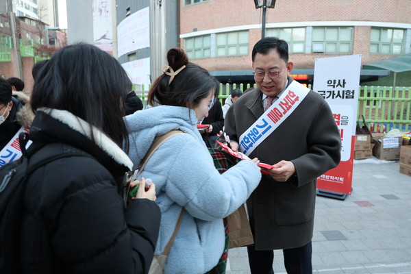 ▲ 최광훈 회장은 수험생들에게 핫팩을 전달하며 응원의 말을 건넸다.