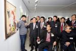 발달장애인 화가 이대호 씨(왼쪽)가 중외학술복지재단 이종호 이사장(왼쪽에서 두 번째), 한국장애인미술협회 김충현 회장(휠체어에 앉은 이) 등에게 작품에 대해 설명하고 있다.