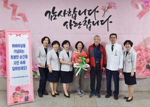 ▲ 민정준 병원장(오른쪽에서 두 번째) 등 의료진들이 병원 1층 로비에 마련된 ‘어버이날 기념 외래 포토존’에서 내원객들과 사진 촬영하고 있다.