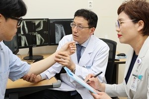 ▲ 전인호 교수(가운데)가 환자가 직접 평가하는 통증 정도를 확인하며 환자 건강상태 자가평가(PROMs)를 진행하고 있다.