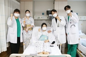 ▲ 다낭성 신증후군으로 만성 신부전을 앓던 이가영 씨(가운데)가 로봇 신장이식 후 순조롭게 회복하며 20일 의료진과 기념사진을 찍고 있다. 왼쪽에서 두 번째가 공여자인 언니 이 모 씨, 네 번째가 수술을 집도한 서울아산병원 신ㆍ췌장이식외과 신성 교수.