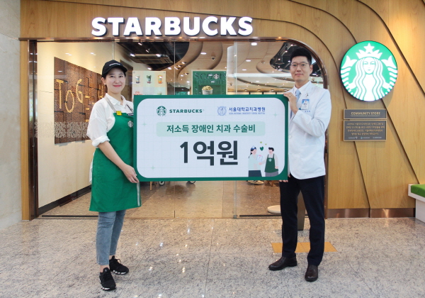 ▲ 스타벅스 서울대치과병원점 최예나 점장(왼쪽)이 서울대치과병원 조정환 대외협력실장에게 저소득 장애인 치과수술비 기금을 전달하고 있다.