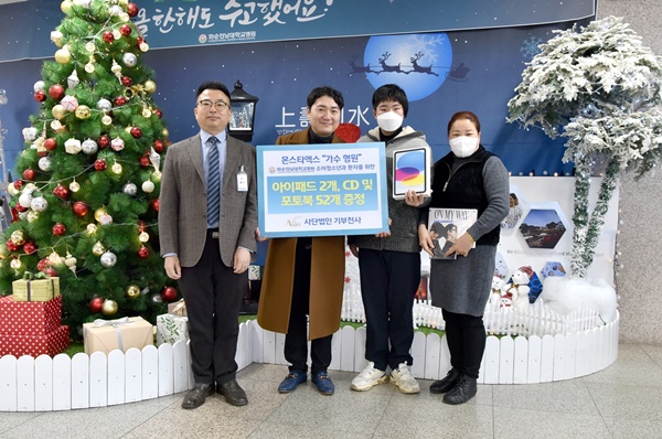 ▲ (왼쪽부터)손오봉 사회사업팀장과 김정주 대표가 몬스타엑스 형원의 익명 팬에게 전달받은 아이패드 등을 소아암 입원 환아와 보호자에게 전달하고 있다.